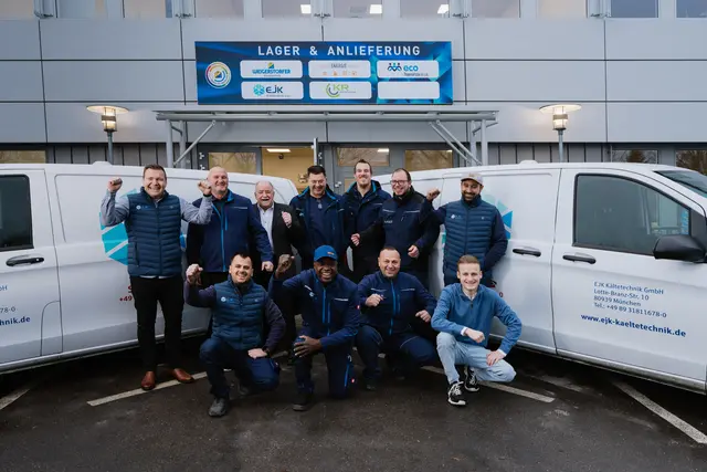 Teamfoto vor den Firmenfahrzeugen