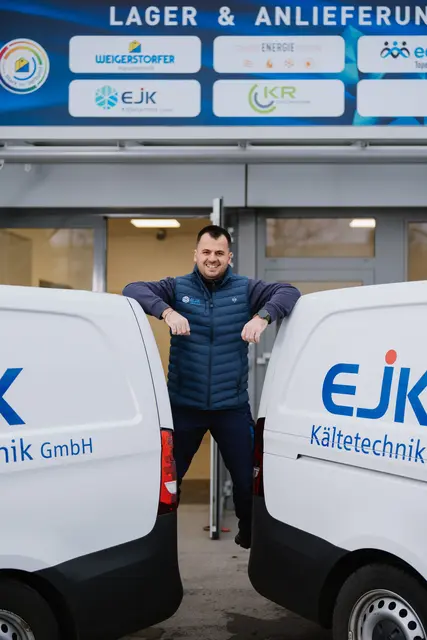 Mitarbeiter zwischen den Firmenfahrzeugen